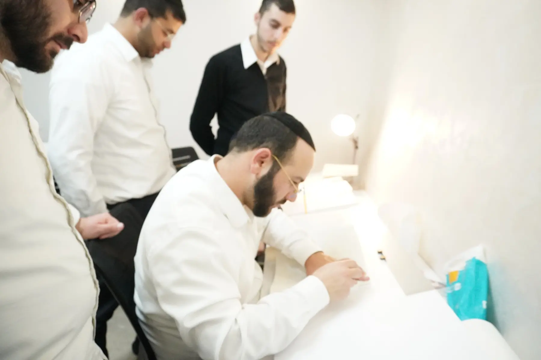 הרב יוחאי אוחיון מעניק תיקון אישי לתלמיד בזמן הכתיבה